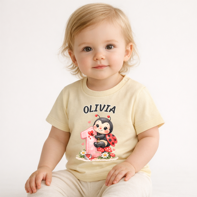 Baby Mädchen trägt personalisiertes T-Shirt zum 1. Geburtstag mit Name Olivia und süßem Marienkäfer Motiv, perfekte Geschenkidee für Geburtstag