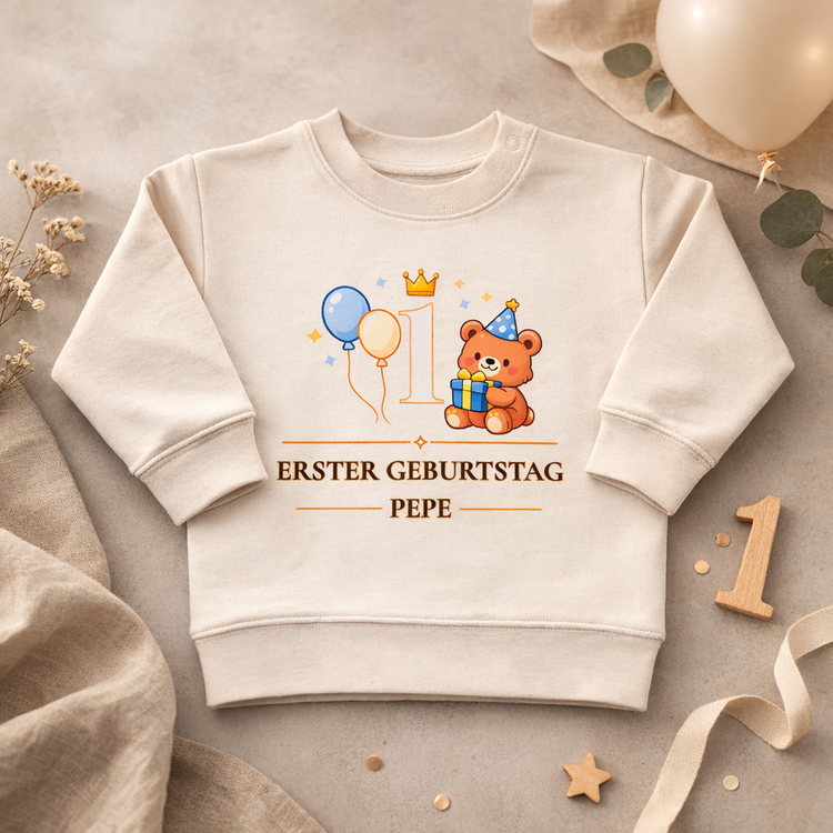 Personalisierter Baby Pullover zum 1. Geburtstag mit süßem Bärenmotiv, Ballons und Krone. Auf dem cremefarbenen Kinder Sweatshirt steht „Erster Geburtstag“ mit individuellem Namen. Perfektes Geschenk zum ersten Geburtstag für Jungen oder Mädchen, ideal für Geburtstagsparty und Fotos.