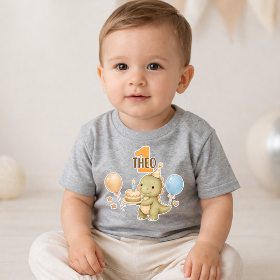 Graues Babyshirt mit Dino und Name Theo zum 1 Geburtstag, süßes Motiv mit Kuchen und Ballons, personalisiertes Geschenk für Kleinkinder