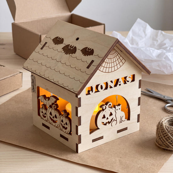 Personalisiertes Halloween Geschenk mit dem Namen JONAS, frisch ausgepackt auf Packpapier mit Karton, Schere und Juteschnur