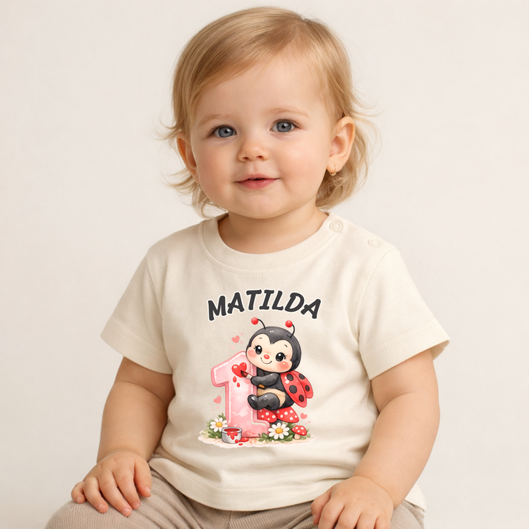 Kleinkind trägt personalisiertes Geburtstagsshirt mit Name Matilda und Marienkäfer Motiv, ideal für ersten Geburtstag und Erinnerungsfotos