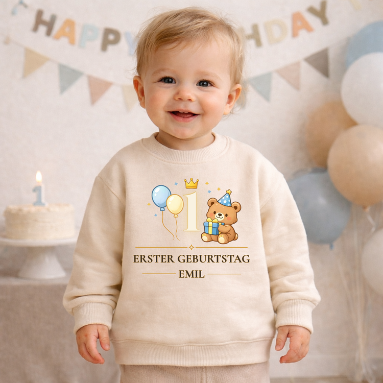 Personalisiertes Baby Outfit zum ersten Geburtstag mit Bär, Ballons und Krone neben der Zahl 1. Der cremefarbene Baby Pullover trägt den Schriftzug „Erster Geburtstag“ und einen individuellen Namen. Perfekt für Geburtstagsfotos, Party oder als Geschenk.